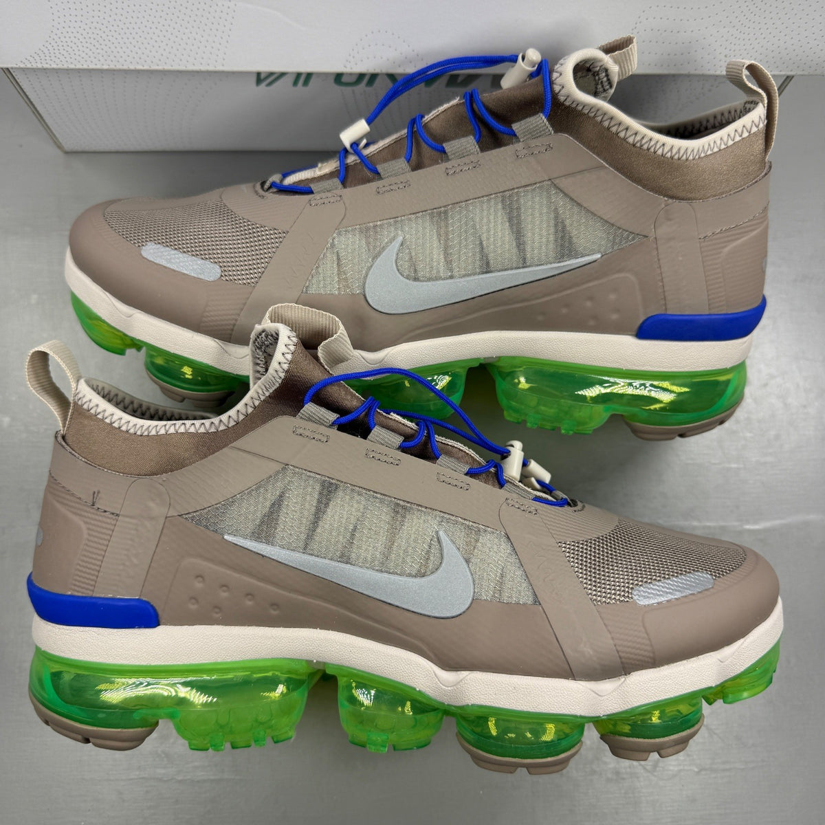 Nike running shoes beige with Air VaporMax sole and utility design.