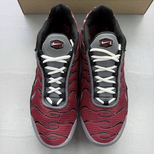 Nike Air Max Plus TN white trainers with red and black accents, featuring logo detailing.
