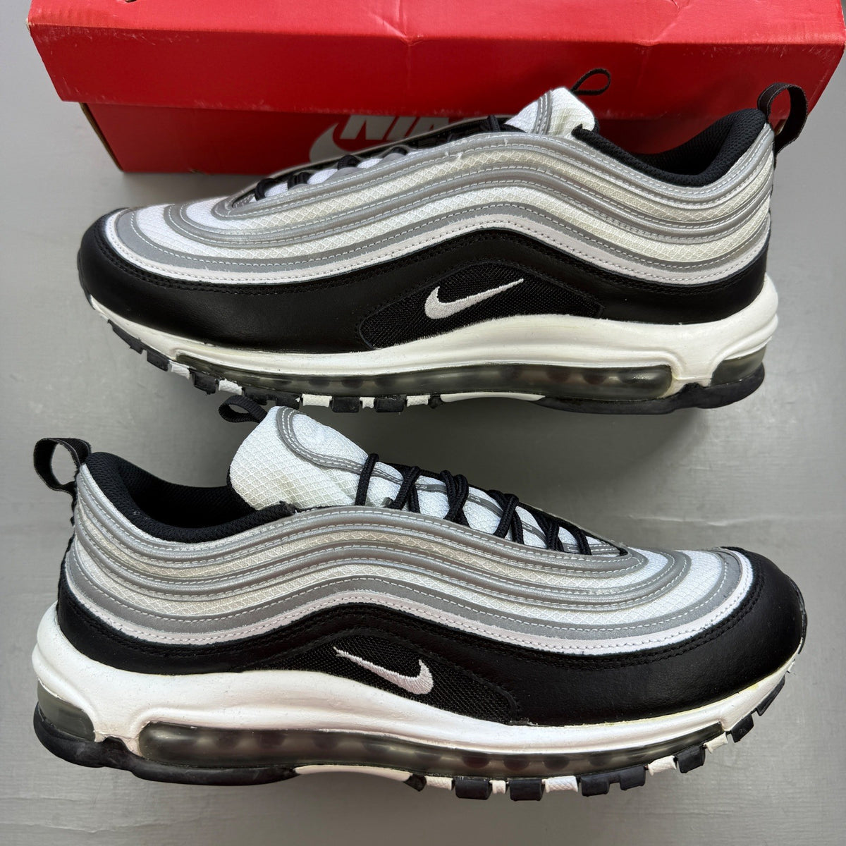 Nike black athletic shoes with metallic silver accents and signature logo detailing.