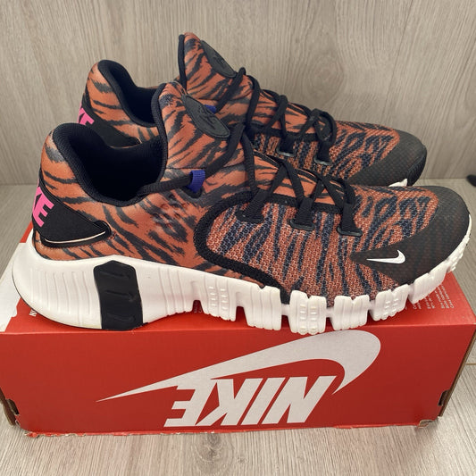 Nike Free Metcon 4 trainers black with tiger burnt sunrise accents and logo detail.