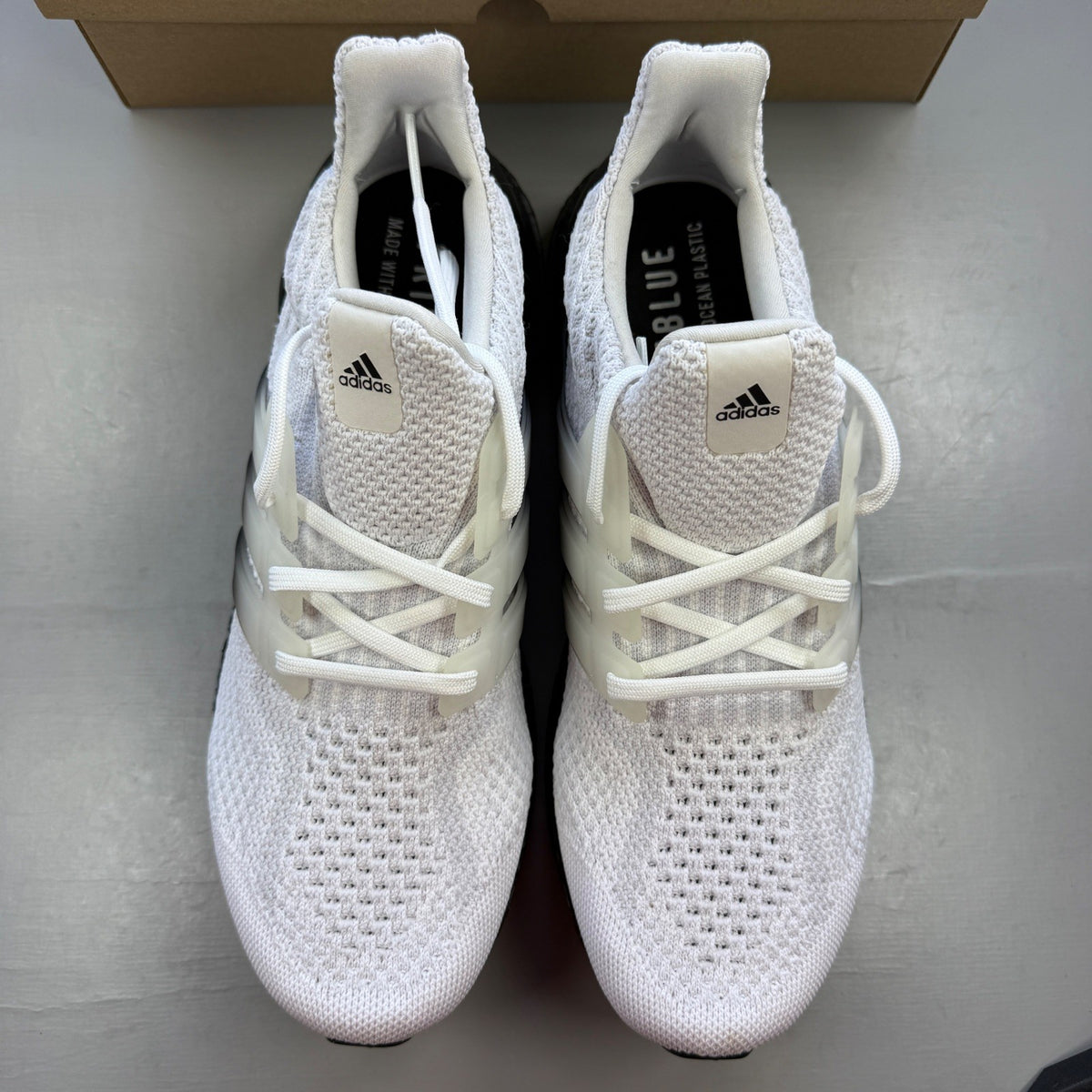 Adidas running shoes white with black accents and Boost cushioning technology.