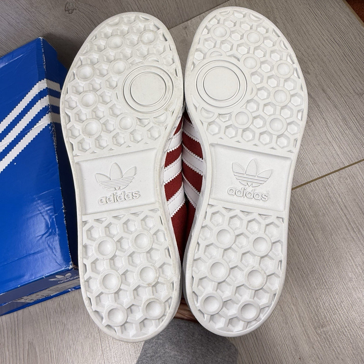 Adidas red trainers with white stripes and logo, classic suede material.