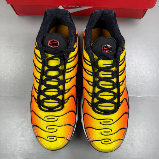 Nike running shoes sunset orange with black accents and distinctive Air Max Plus design.