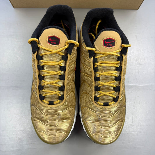 Nike gold trainers with metallic finish and distinctive Air Max Plus TN design.