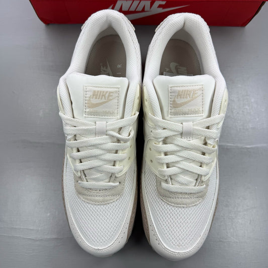 Nike Air Max 90 beige trainers with premium material and iconic logo detail.