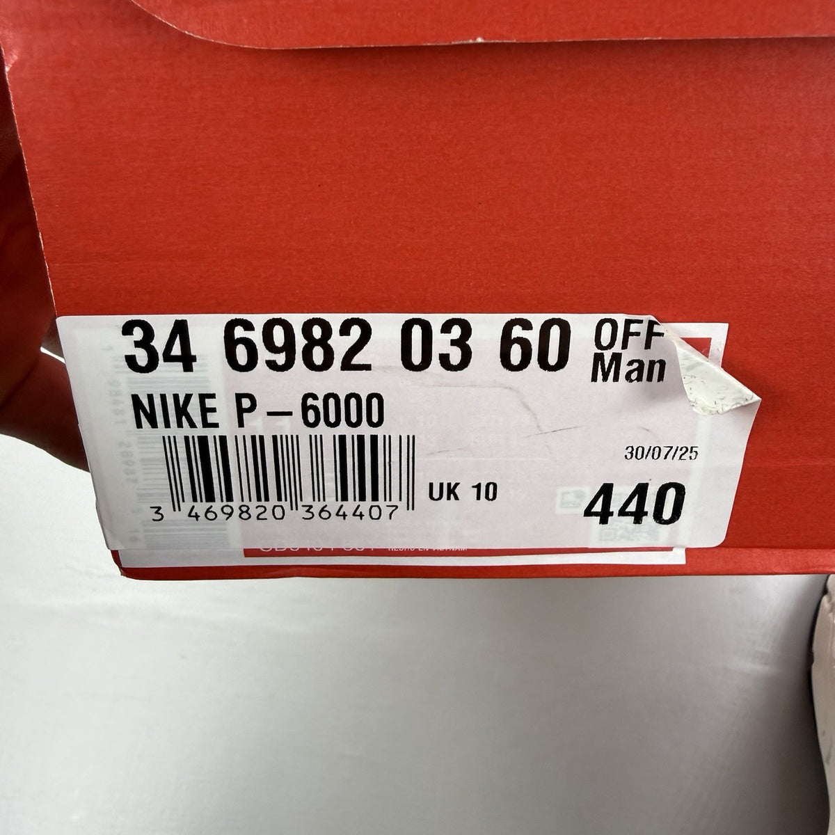 Nike white trainers with bright crimson red accents and soft pearl cream detailing.