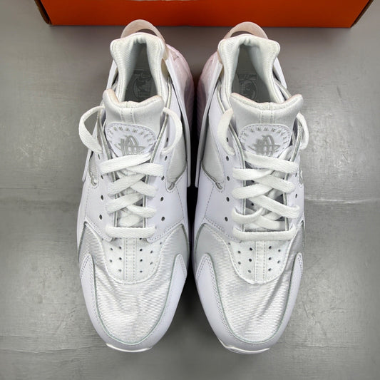 Nike Air Huarache white trainers with mesh upper and signature logo detailing.
