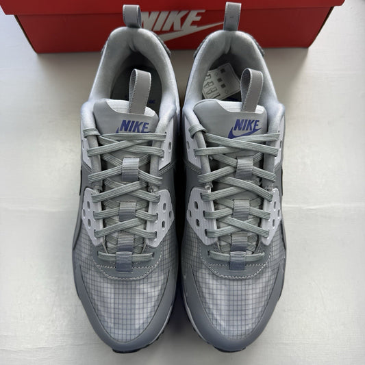 Nike Air Max 90 Drift grey trainers with deep royal blue accents and logo detail.