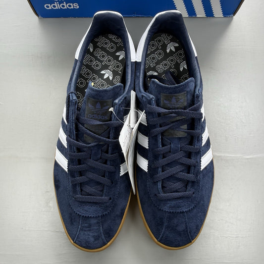 Adidas blue trainers with white and gum sole, featuring gold accents and logo.