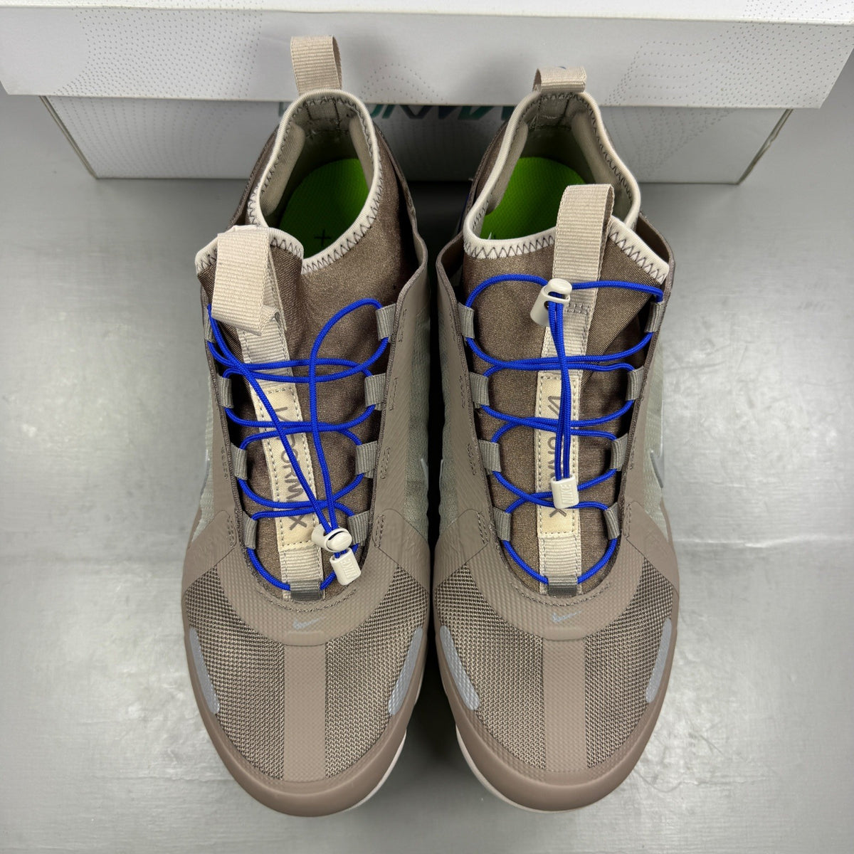 Nike running shoes beige with Air VaporMax sole and utility design.