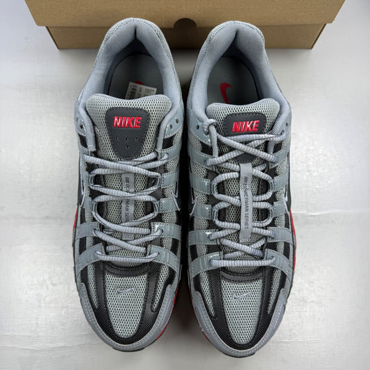 Nike grey trainers with red accents and black detailing, featuring a sleek design.