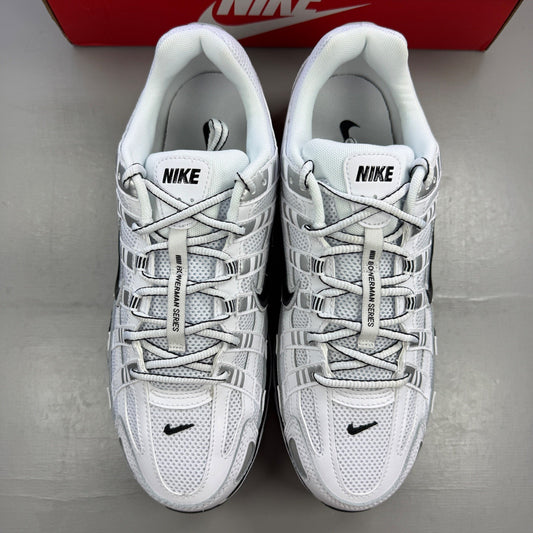 Nike white trainers with metallic silver accents and black detailing, featuring a sleek design.