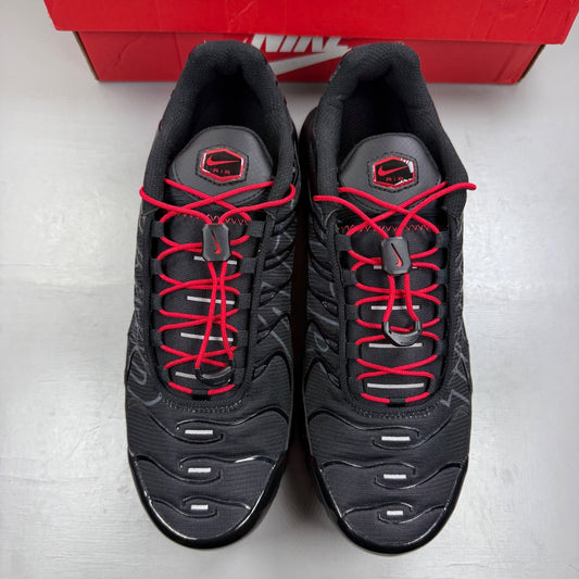 Nike Air Max Plus TN black trainers with red accents and iconic Tuned Air sole.