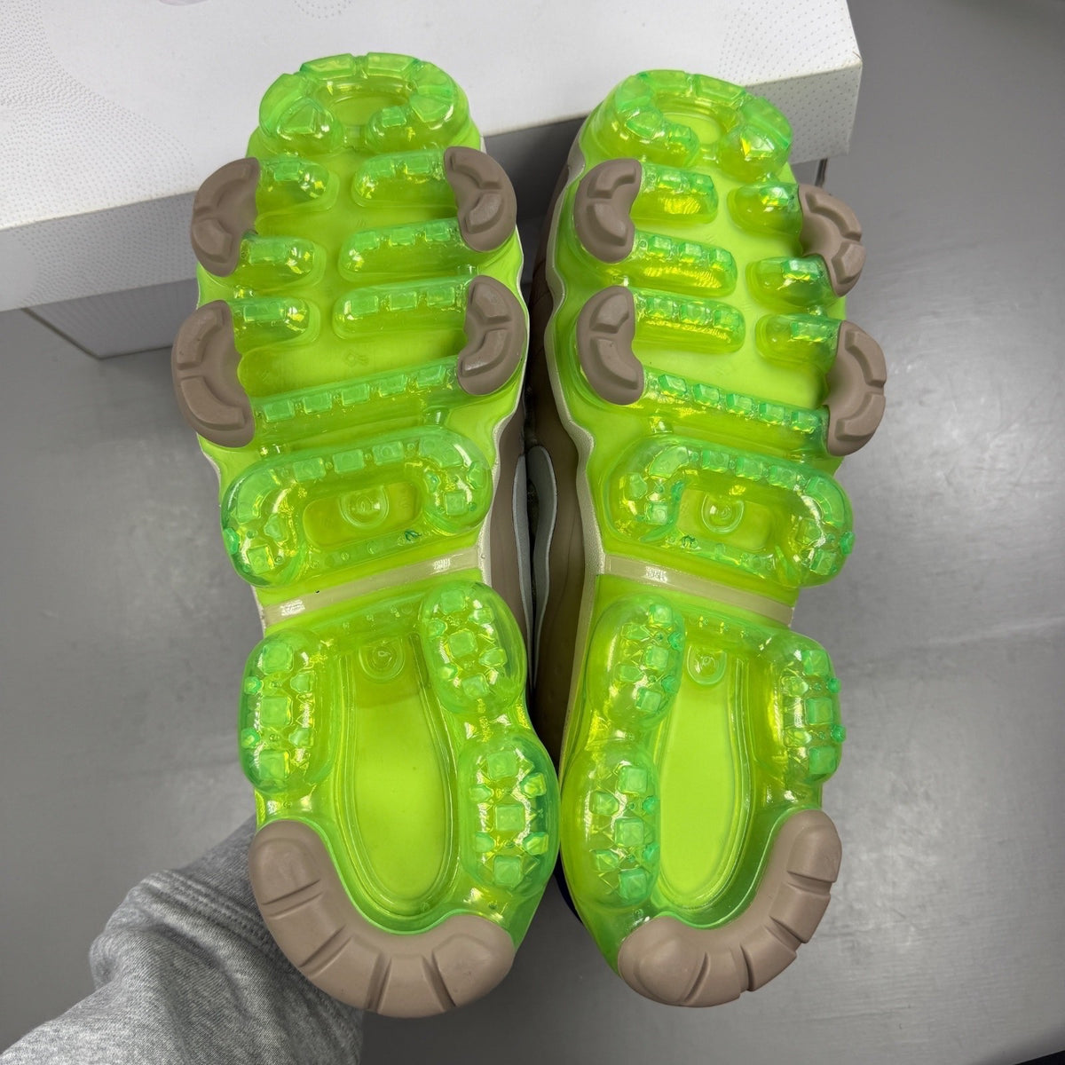 Nike running shoes beige with Air VaporMax sole and utility design.