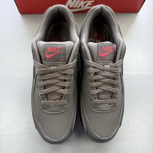 Nike Air Max 90 trainers grey with red accents and logo detail.
