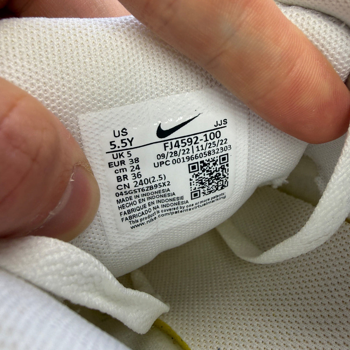 Nike Air Max 90 white athletic shoes featuring double swoosh logo and sleek design.