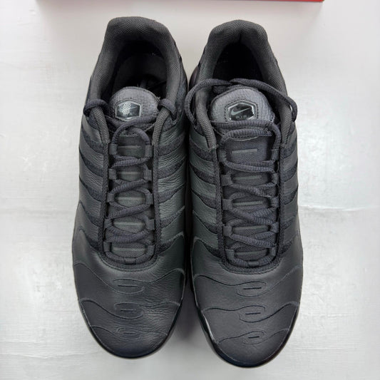 Nike Air Max Plus TN black leather trainers with distinctive wave pattern and logo.