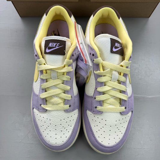Nike Dunk Low purple trainers with soft yellow accents and classic swoosh logo.