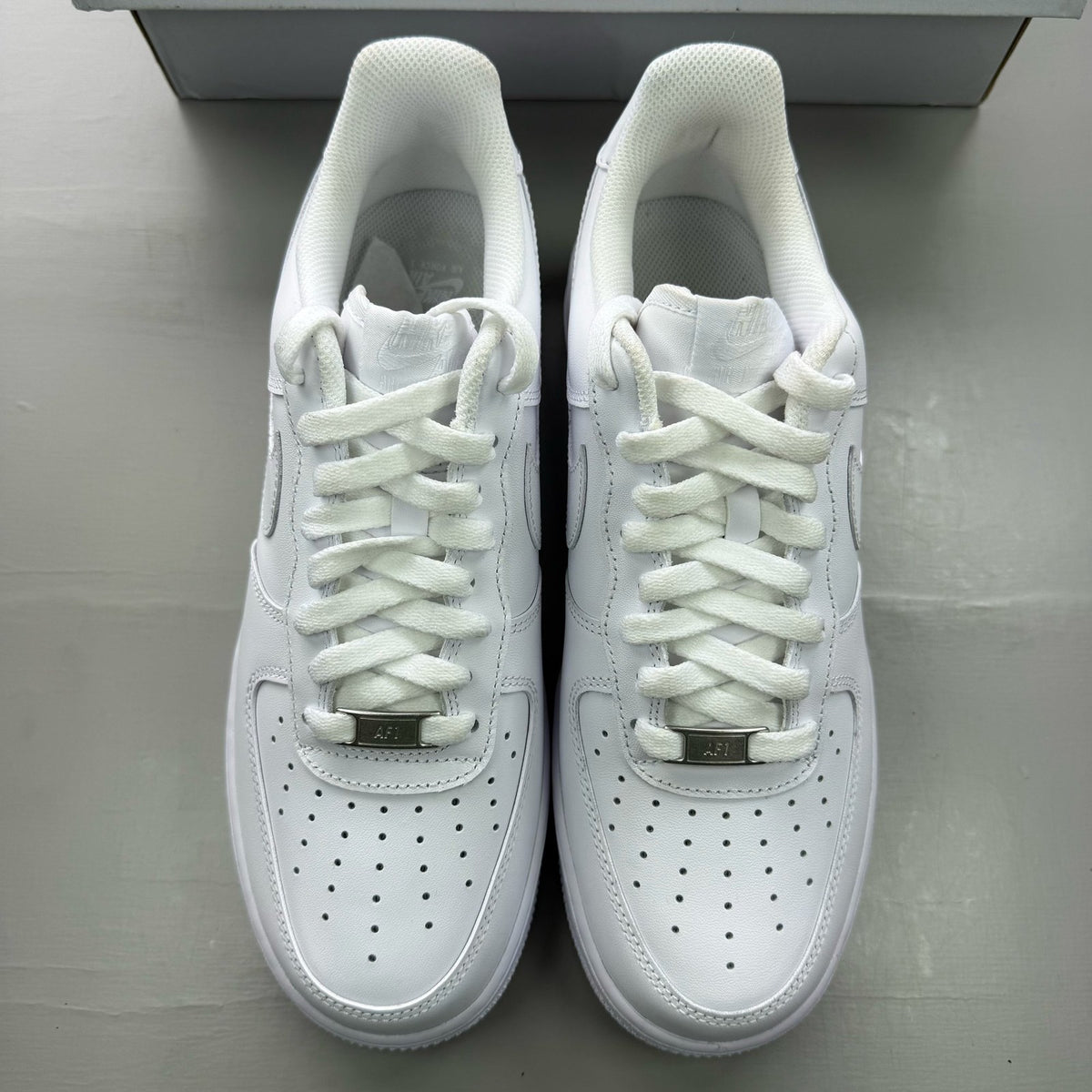 Nike Air Force 1 '07 white trainers with classic silhouette and embossed logo.