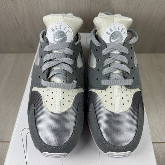 Nike white trainers with grey accents and signature logo on the tongue.