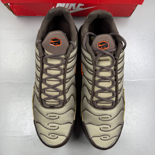 Nike Air Max Plus TN brown athletic shoes with safety orange accents and logo details.