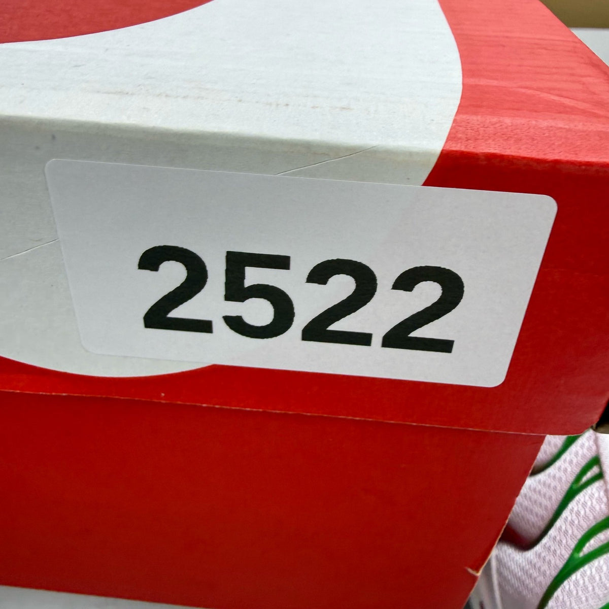 Nike Air Max Plus TN white trainers with green and red accents, featuring iconic logo.