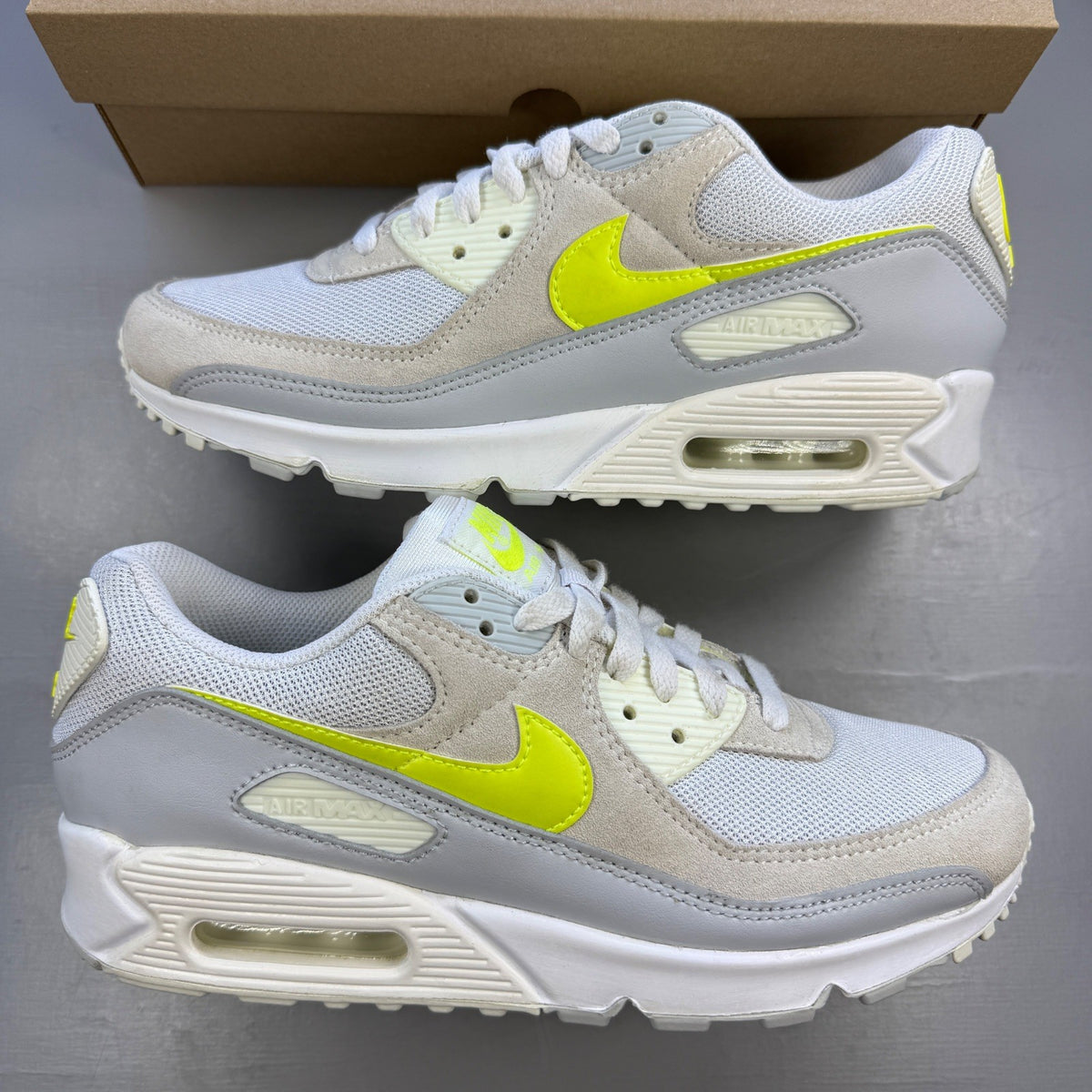 Nike white trainers with lemon venom accents and Air Max logo detail.