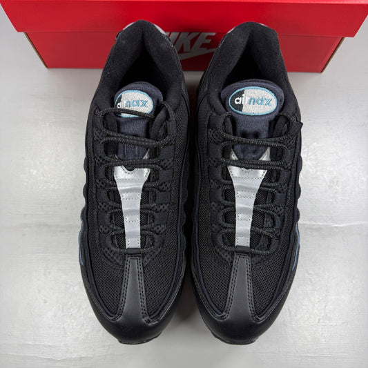 Nike running shoes black with smokey blue accents and visible Air Max cushioning.