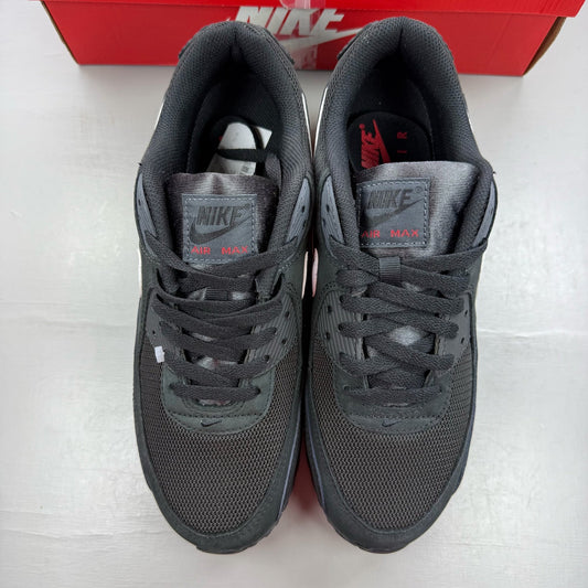 Nike Air Max 90 black trainers with red and white accents, featuring logo detail.