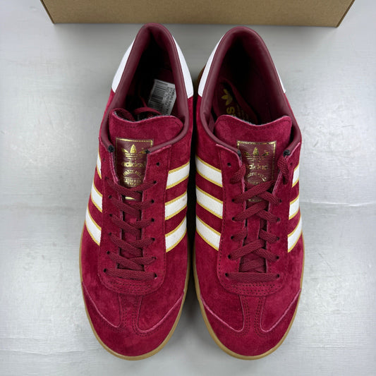 Adidas red athletic shoes with white stripes and gum sole, size UK 7.5.