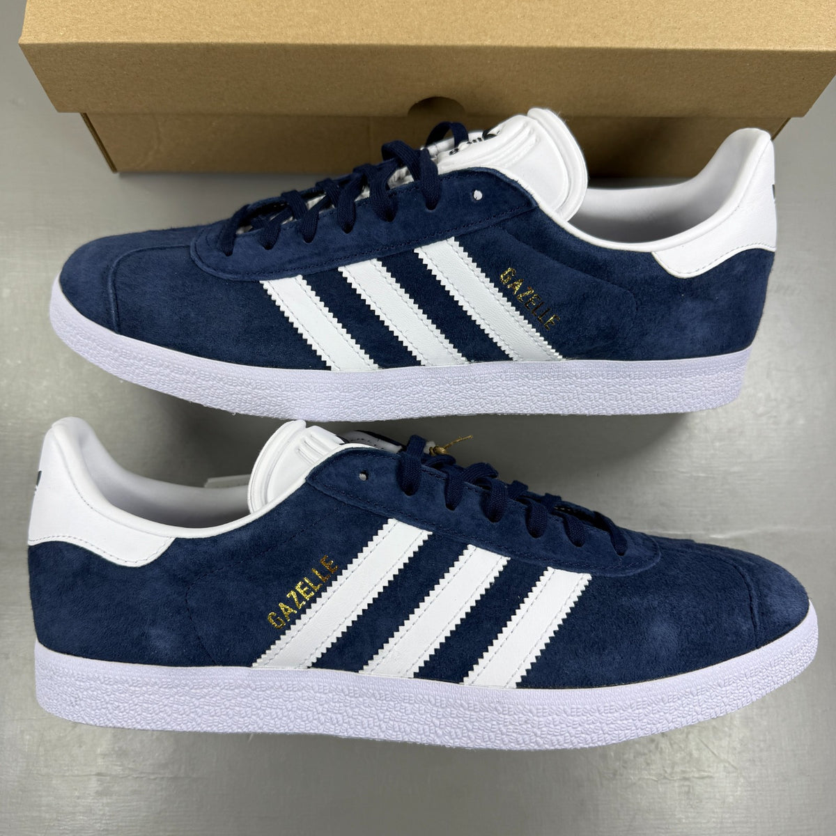 Adidas blue suede trainers with white stripes and logo detail.