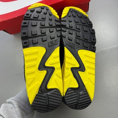 Nike trainers grey with yellow accents, featuring Air Max cushioning and logo detail.