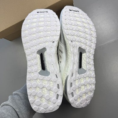 Adidas white trainers with mesh upper and Boost cushioning technology.
