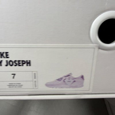 Nike trainers white with black snakeskin pattern and logo detail.