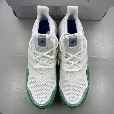 Adidas white trainers with green accents and Boost cushioning technology.