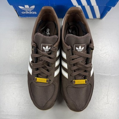 Adidas brown trainers with white accents and classic three-stripe logo.