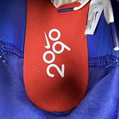Nike white trainers with red and blue accents, featuring Air Max cushioning and logo.