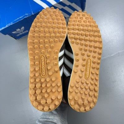 Adidas brown trainers with white accents and classic three-stripe logo.