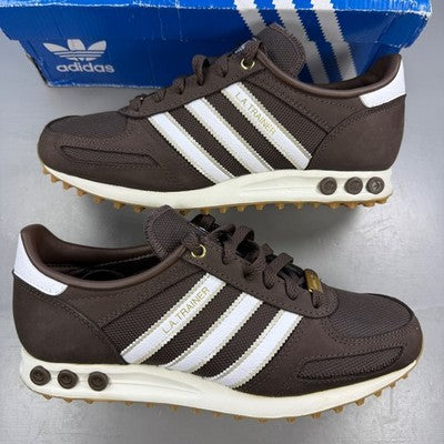 Adidas brown trainers with white accents and classic three-stripe logo.