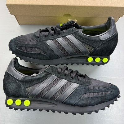Adidas Originals black and yellow trainers with iconic three stripes and cushioned sole.