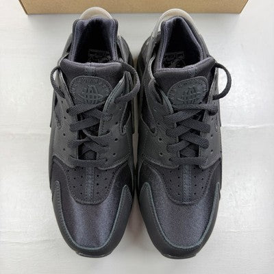Nike black trainers with Huarache design and textured upper, featuring logo details.