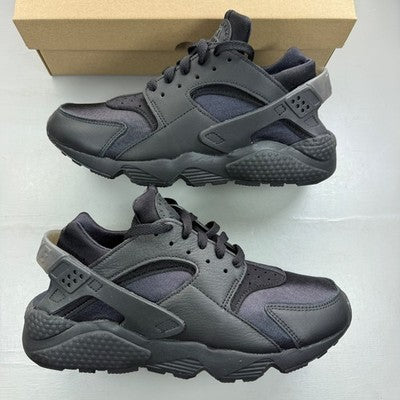 Nike black trainers with Huarache design and textured upper, featuring logo details.