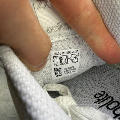 Adidas deck shoes white with minimalist design and iconic three stripes logo.