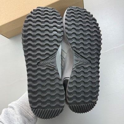 Adidas grey trainers with woven texture and signature three stripes logo.