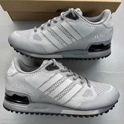 Adidas grey trainers with woven texture and signature three stripes logo.
