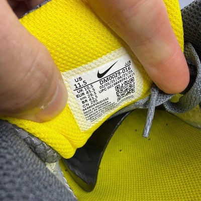 Nike trainers grey with yellow accents, featuring Air Max cushioning and logo detail.