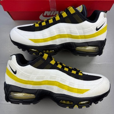 Nike trainers white with black and saffron accents, featuring iconic Air Max bubble sole.