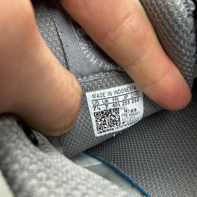 Adidas grey trainers with woven texture and signature three stripes logo.