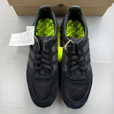 Adidas Originals black and yellow trainers with iconic three stripes and cushioned sole.