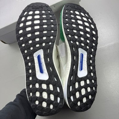 Adidas white trainers with green accents and Boost cushioning technology.